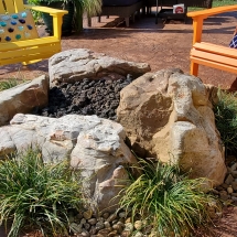 Boulder stone gas fire pit with lava rock