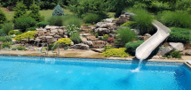 Custom pool slide with waterfall stone steps boulder stone landscaping